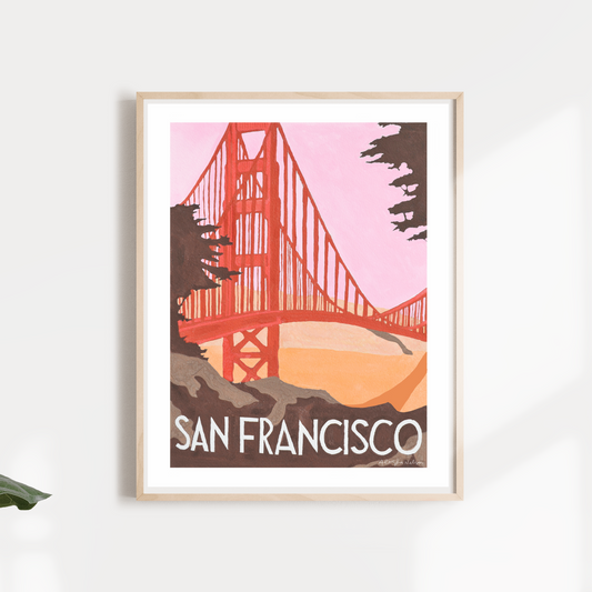 A framed travel poster depicting the Golden Gate Bridge with a pink and orange color scheme, titled 'San Francisco'.