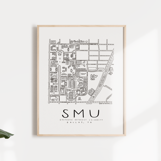 Black and white print of Southern Methodist University campus map, framed and displayed against a neutral background with green leaves to the sides.