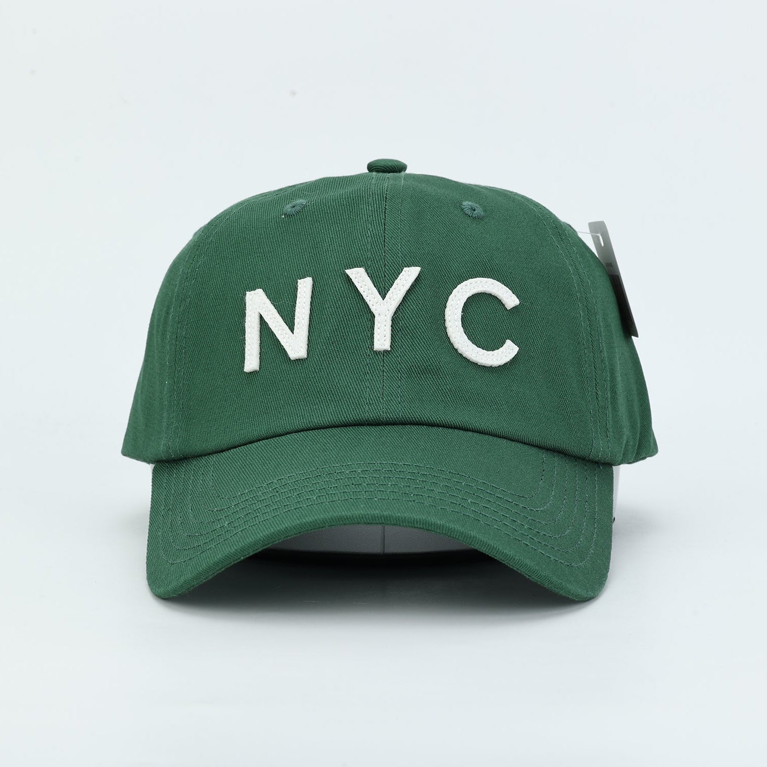 Forest Green Dad Hat with ivory felt cutout letters spelling "NYC"